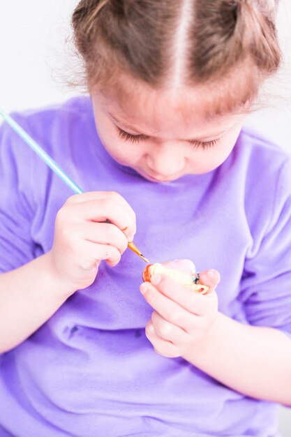 Menina pintando sobre tela com tinta arcílica.