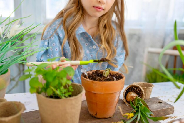 Foto menina plantando flores no terraço de primavera em casa jardim mudas crescendo veranda de casa de campo