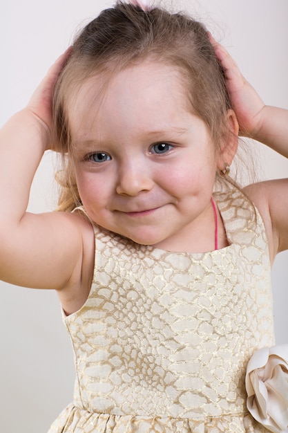 Menina posa em lindo vestido em fundo cinza