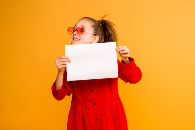 Menina pré-adolescente, segurando o papel branco em branco