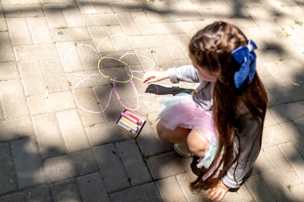 Menina pré-escolar pintando com giz colorido Atividade criativa de crianças ao ar livre no verão