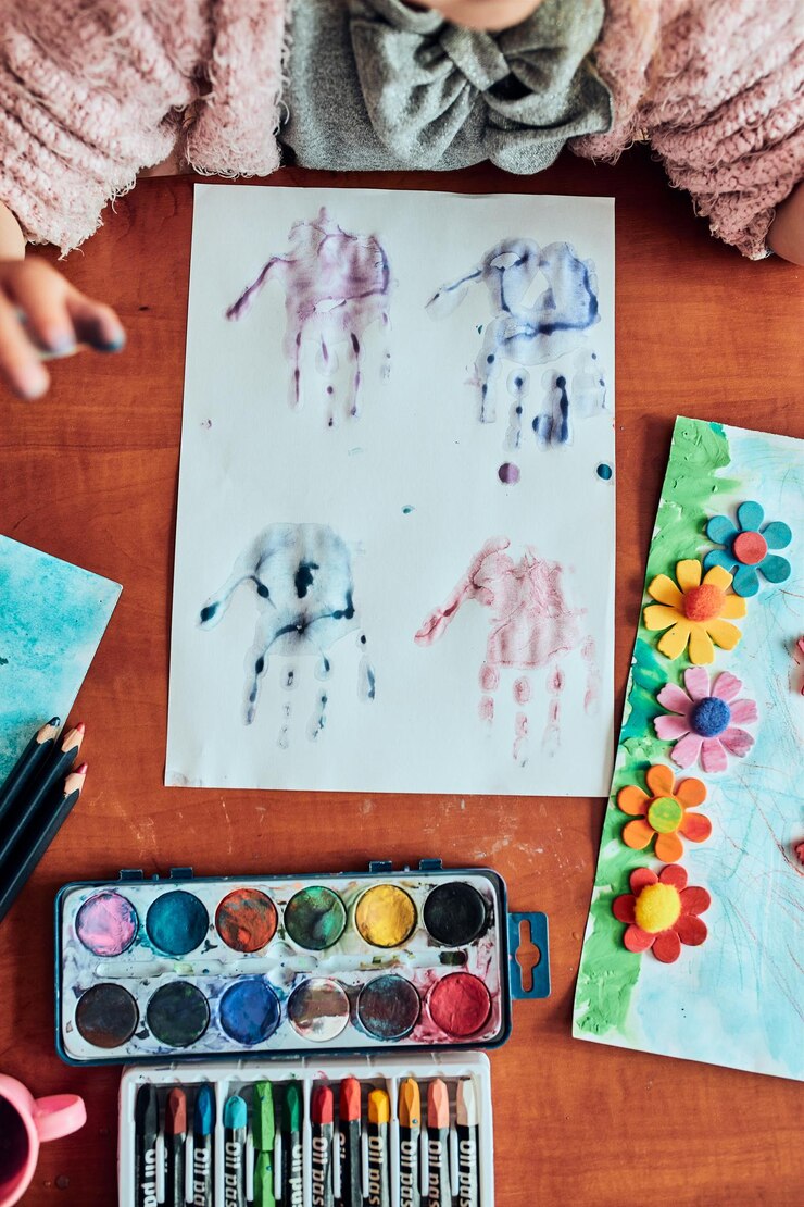 Foto menina pré-escolar pintando um quadro usando tintas coloridas e lápis de cor criança se divertindo