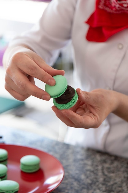 Menina preparando macarons com as mãos. Feche a foto.