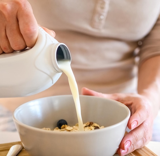 Menina preparando o pequeno-almoço da manhã com aveia