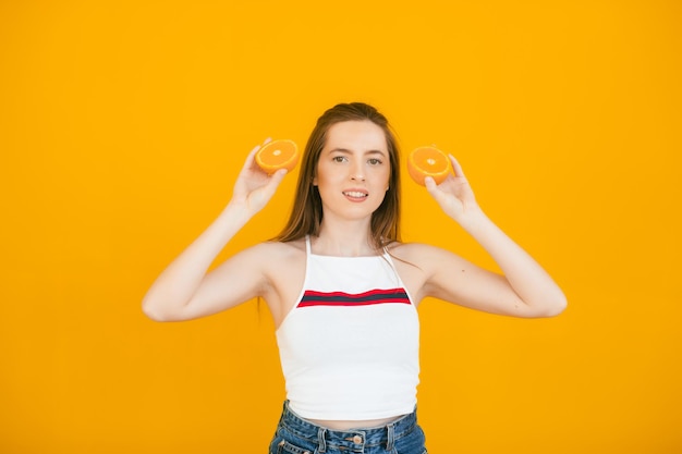 Foto menina pura com dois pedaços de laranja