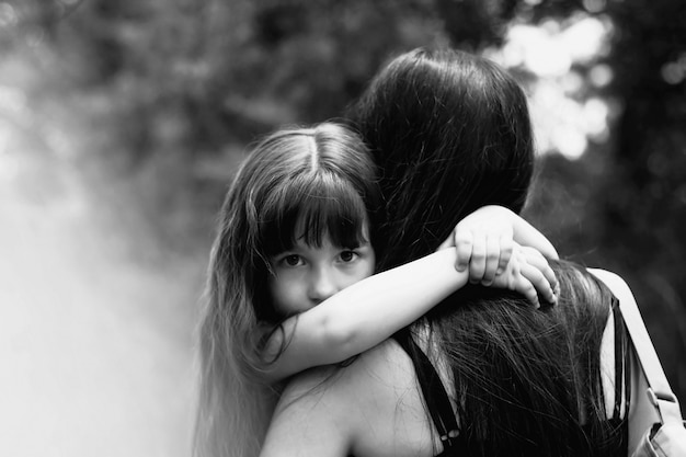 Foto menina que abraça sua mãe