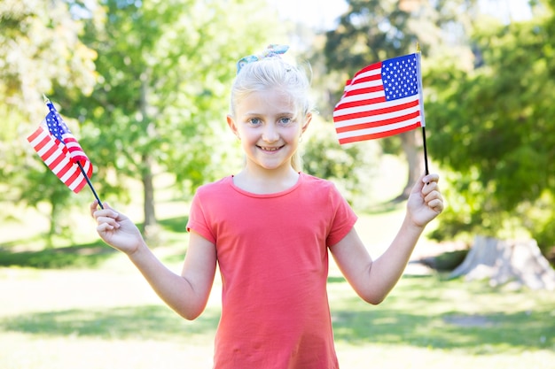Menina que acena bandeira americana