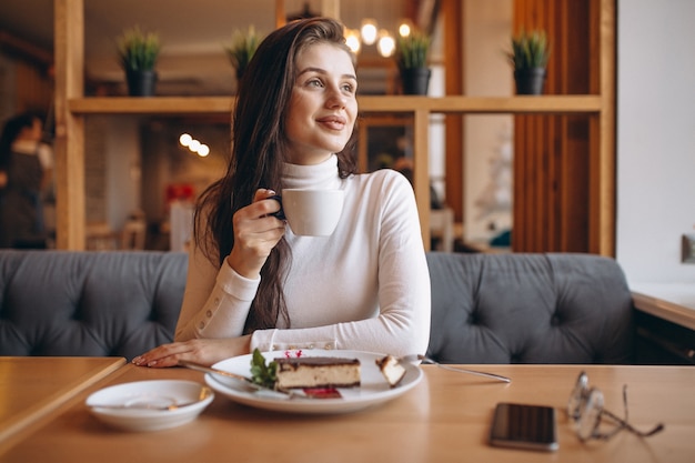 Menina que almoça em um café