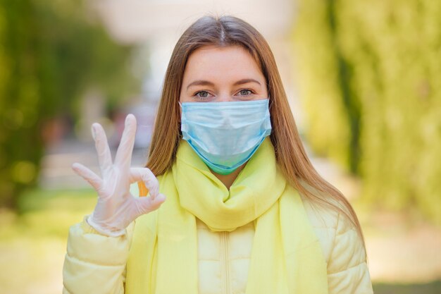 Menina que desgasta a máscara protetora médica, retrato ao ar livre.