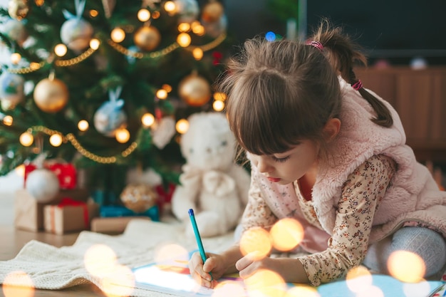 Menina que escreve uma letra do natal