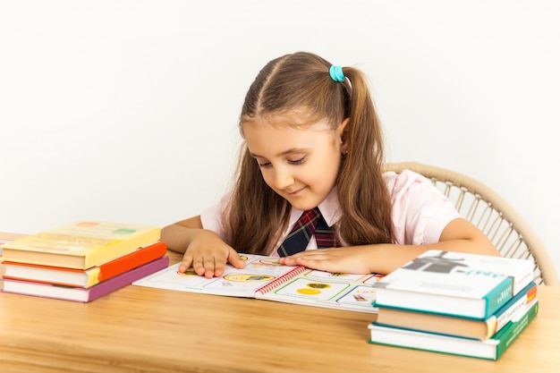 Menina que estuda na tabela no fundo branco