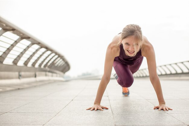 Menina que faz exercício montanhista na ponte