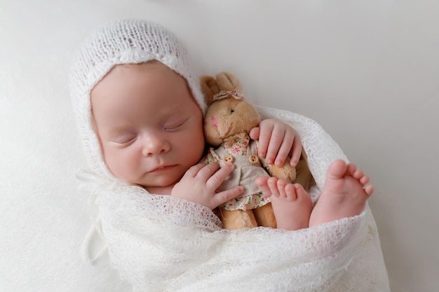 Menina recém-nascida com um coelho de brinquedo nas mãos