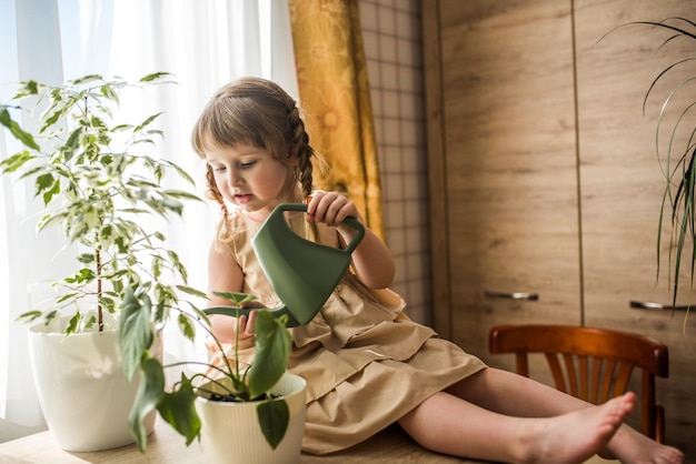 Foto menina regando plantas em casa