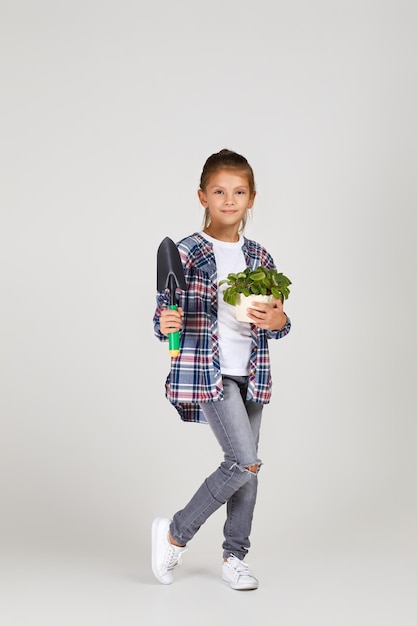 Menina regando plantas em um vaso de flores