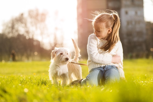 Menina relaxante com seu cachorrinho no parque