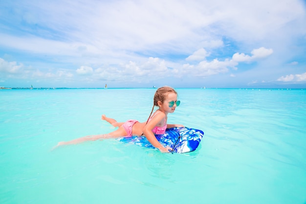 Menina relaxante no colchão de ar inflável no mar