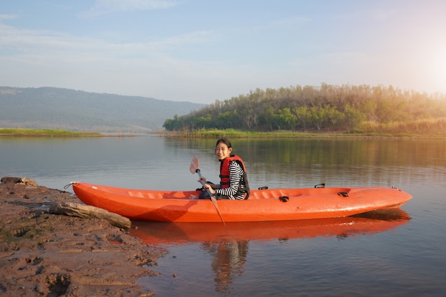 Menina remando uma canoa em águas calmas