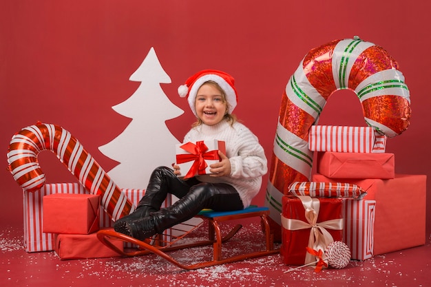 Menina rodeada de presentes e elementos de natal