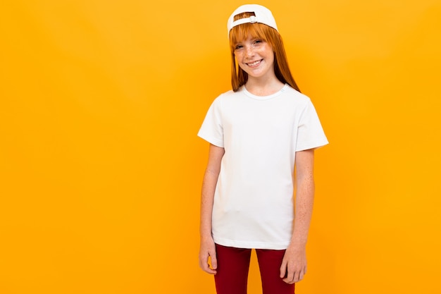 Menina ruiva alegre em uma laranja em uma camiseta branca sem inscrições