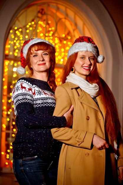 menina ruiva com a mãe na noite de inverno na rua