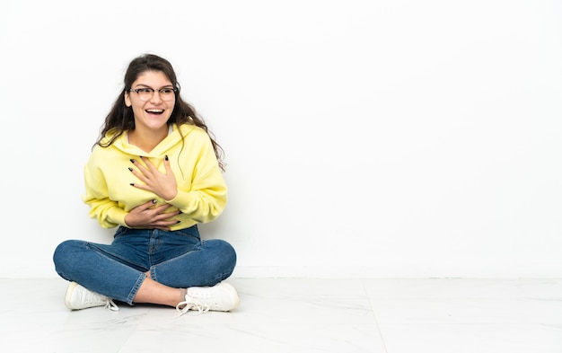 Menina russa adolescente sentada no chão sorrindo muito