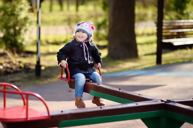 Menina se divertindo com carrossel no playground ao ar livre