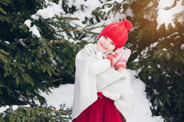 Menina se divertindo na floresta de inverno