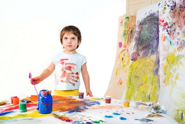 Menina segura escova nas mãos e desenha