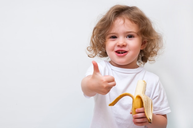 Menina segurando banana amarela e mostrar o polegar para cima