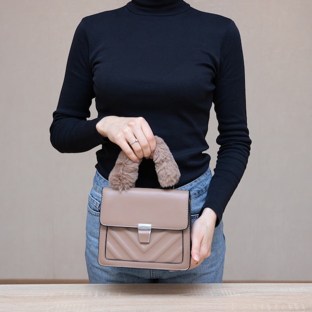 Menina segurando bolsa nas mãos