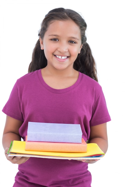 Foto menina segurando cadernos e livros para a lição de casa