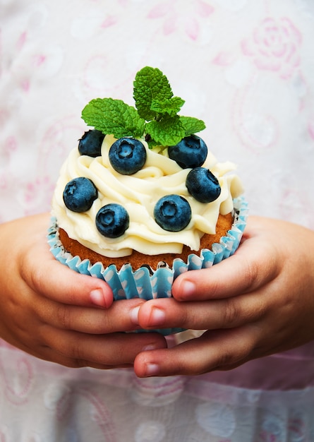 Menina segurando cupcake