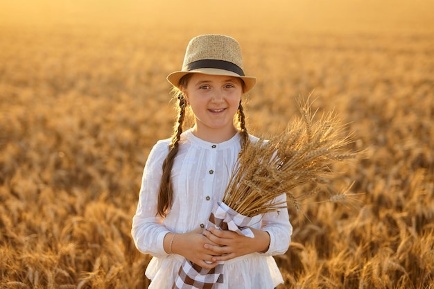 Menina segurando espigas de milho em suas mãos