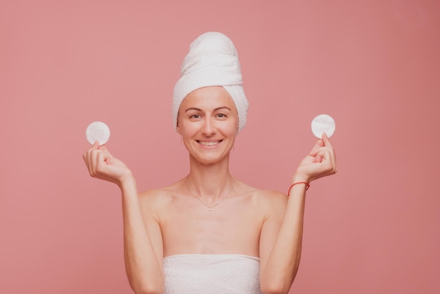 Menina segurando esponjas para remover maquiagem nos olhos