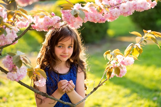 Menina segurando flor de cereja