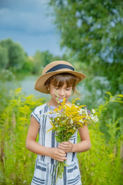 Menina segurando flores silvestres nas mãos de uma criança