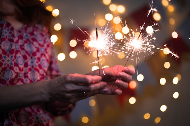 Foto menina segurando luzes de bengala - feliz natal e boas festas