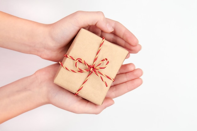 Menina segurando nas mãos uma caixa de presente de Natal ou Ano Novo