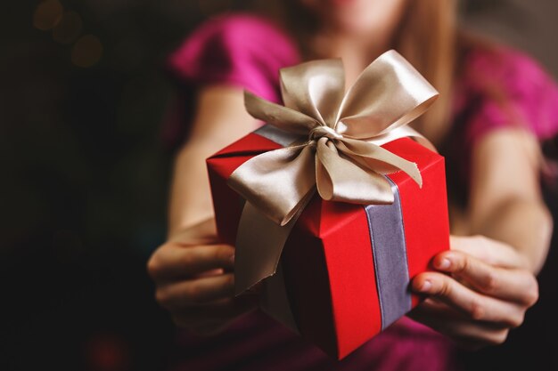 Menina segurando presentes de natal nas mãos, feliz ano novo