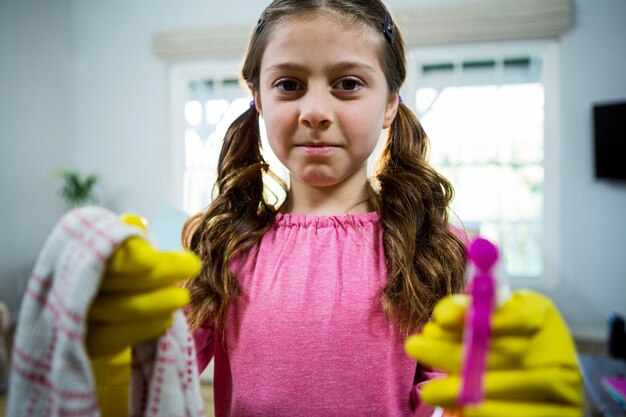 Menina segurando produtos de limpeza