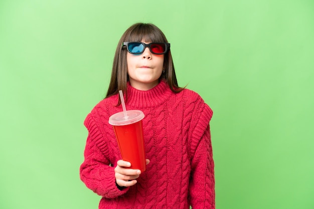 Menina segurando refrigerante sobre fundo croma chave isolado e olhando para cima