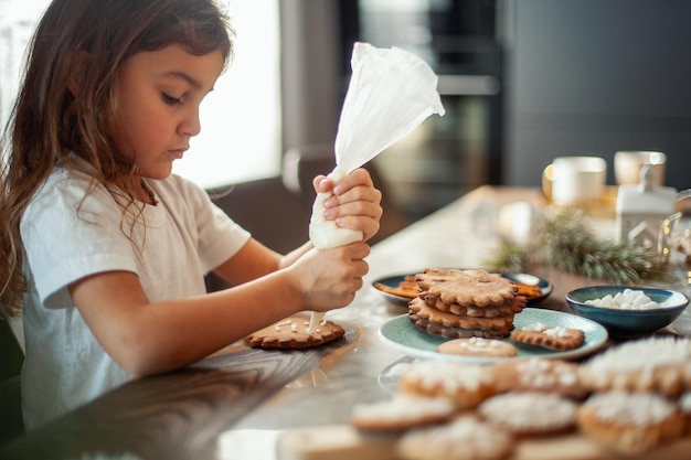 Menina segurando sorvete na mesa em casa