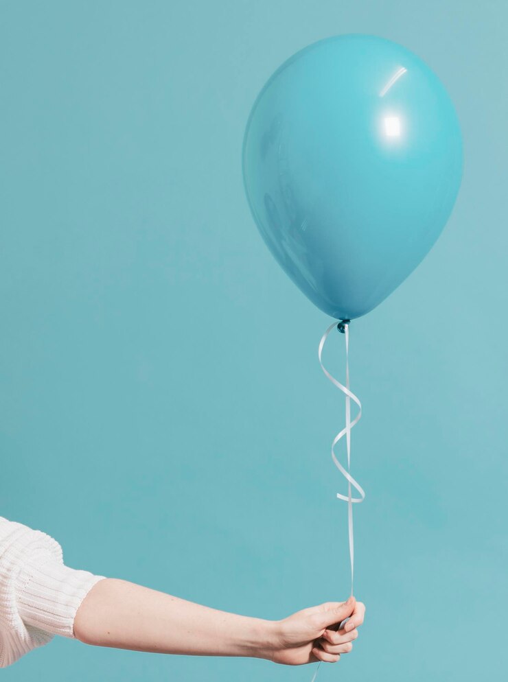 Menina segurando um balão azul pastel