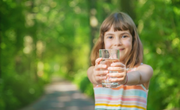 Menina segurando um copo de água