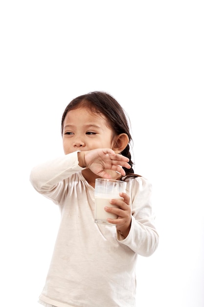 Foto menina segurando um copo de leite contra um fundo branco