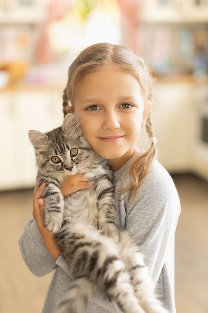 Menina segurando um gatinho fofo nos braços