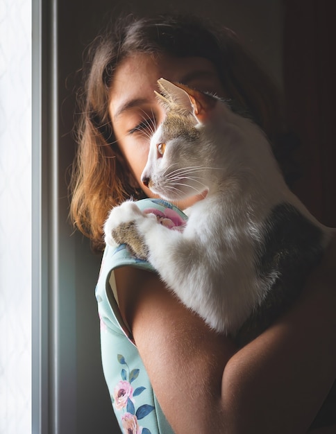 Menina segurando um gato de rua