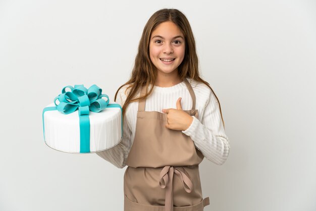 Menina segurando um grande bolo sobre uma parede branca isolada com expressão facial surpresa