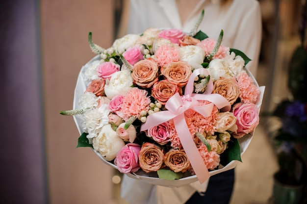 Menina segurando um lindo buquê de flores de cores rosadas diferentes